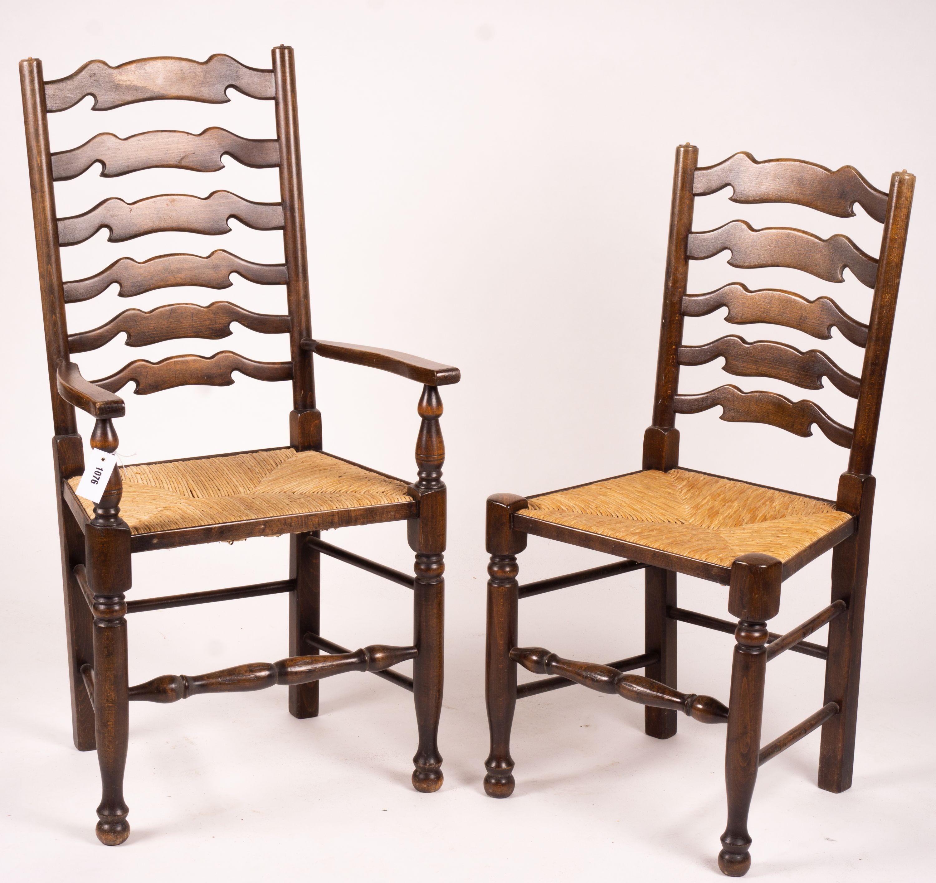 A set of ten 18th century style beech ladderback rush seat dining chairs, two with arms
